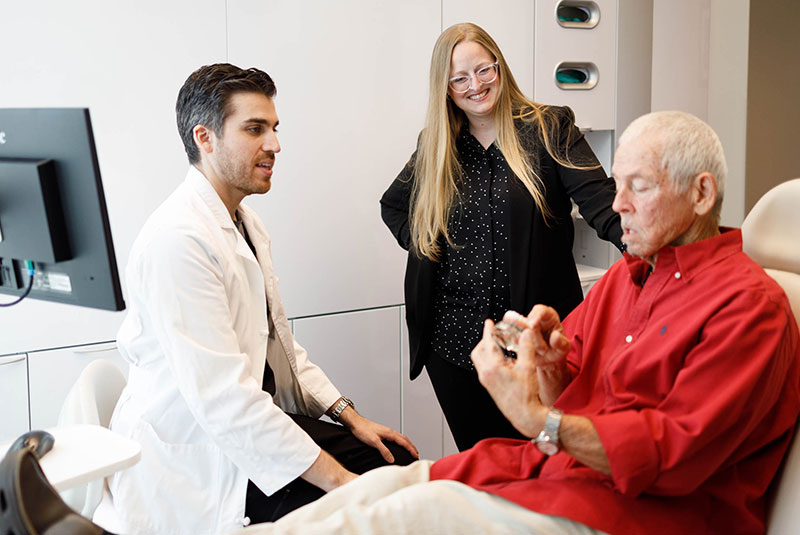 patient looking at dental implant model with doctor and going over dental procedure information