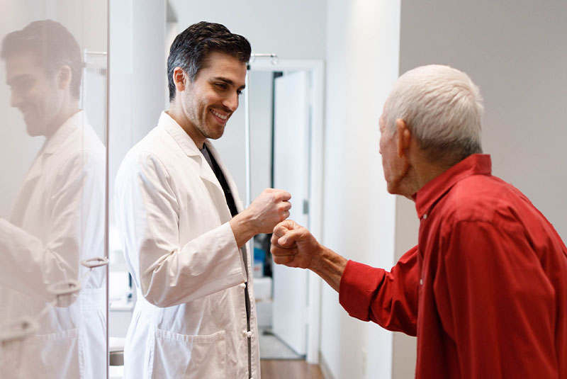 patient and doctor fist bumping after patient's dental procedure